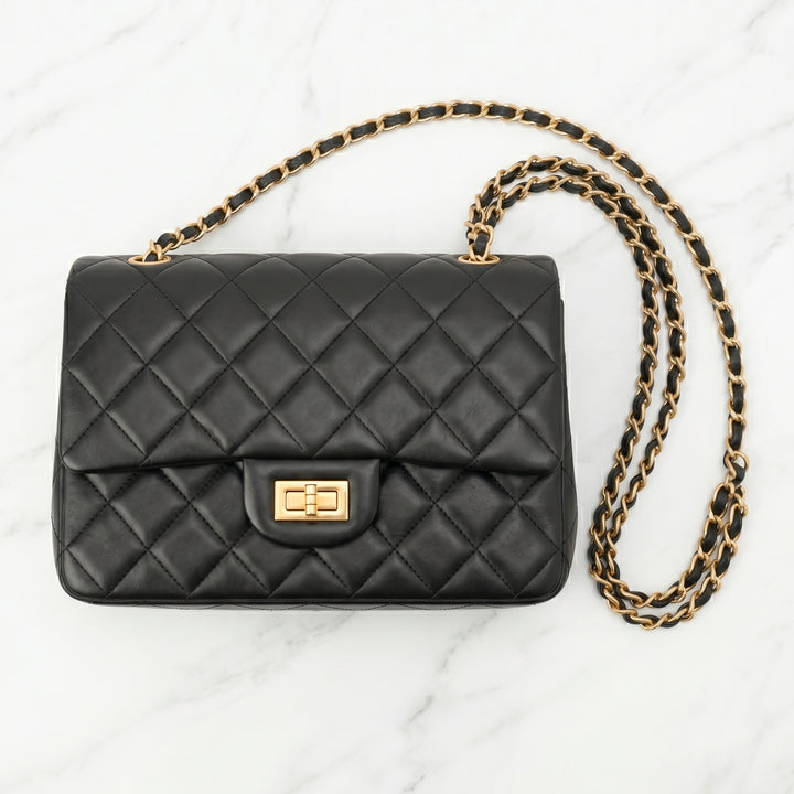 Black quilted handbag with a gold chain front