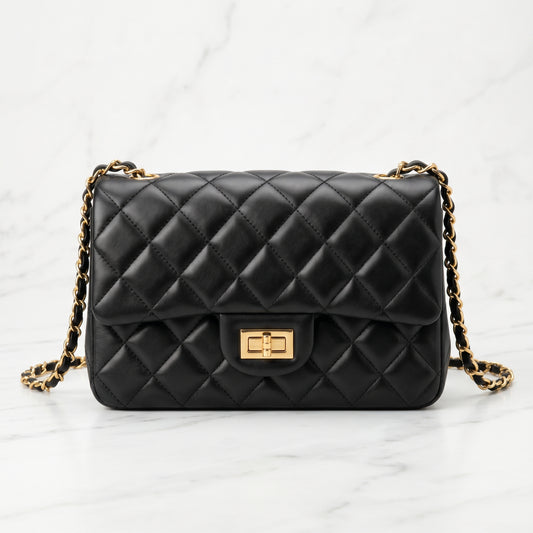 Black quilted handbag with gold chain strap on a white background