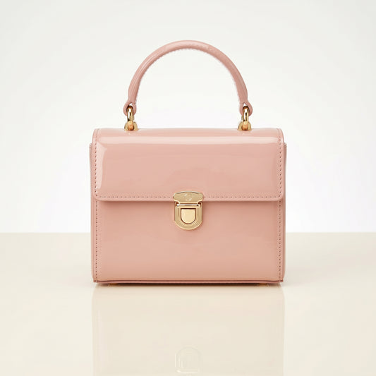Pink handbag with gold accents on a light beige background