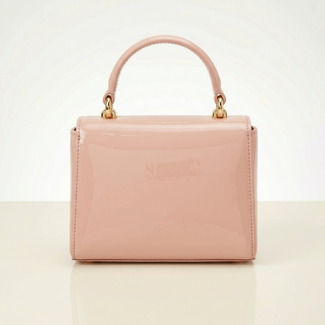 Pink handbag with gold handle on a light beige background