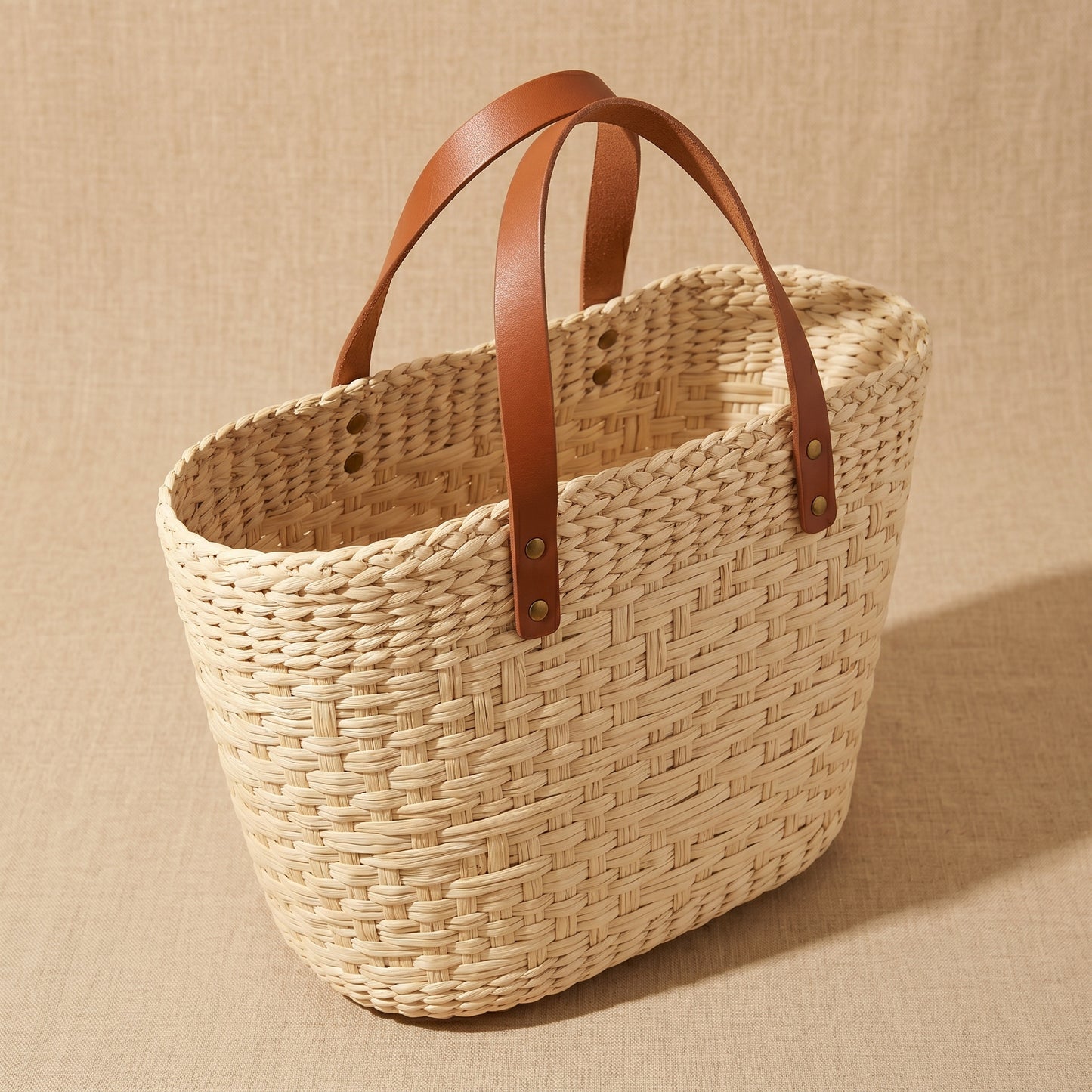 Woven basket with brown leather handles 