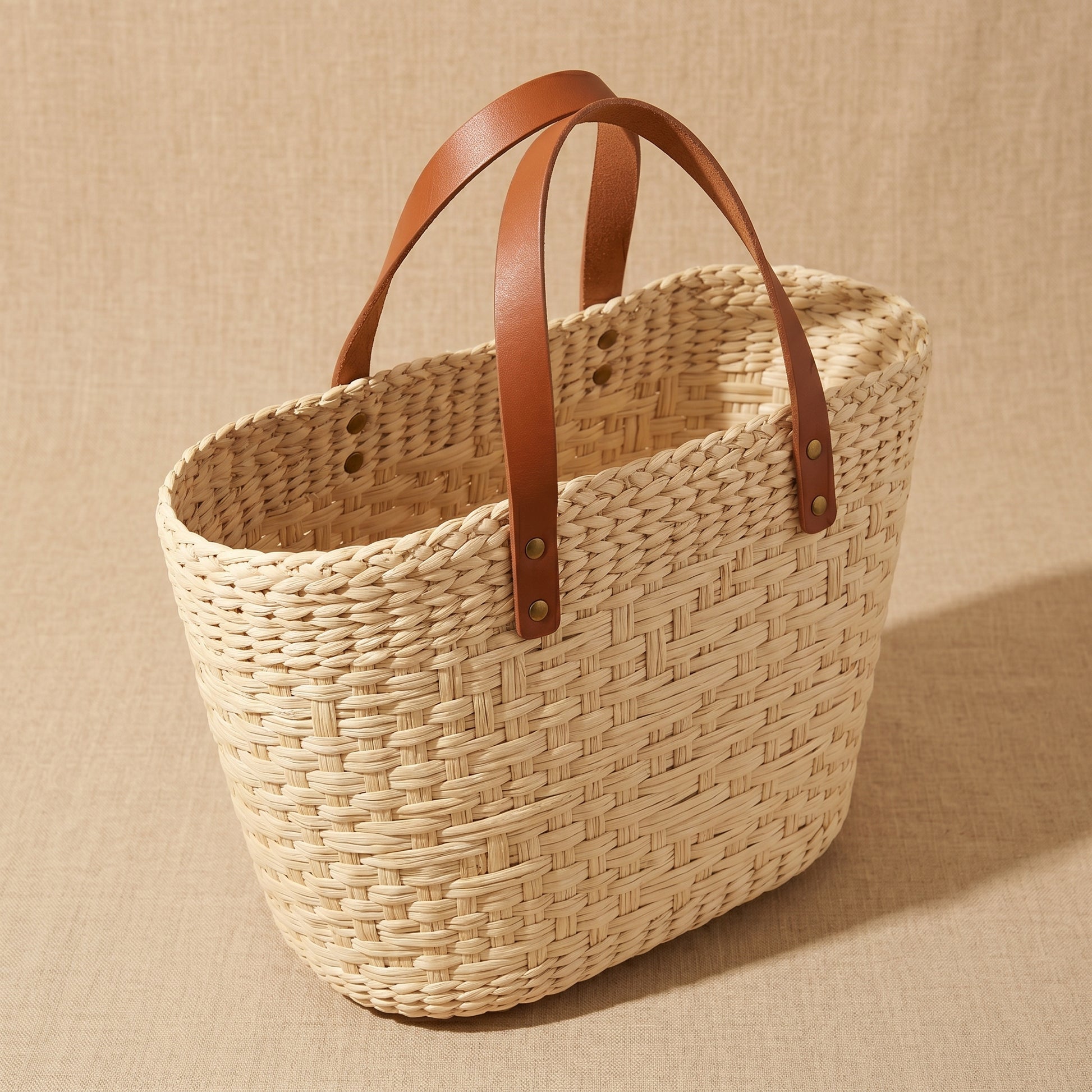Woven basket with brown leather handles 