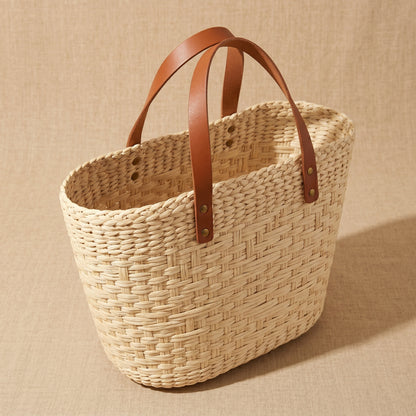 Woven basket with brown leather handles 