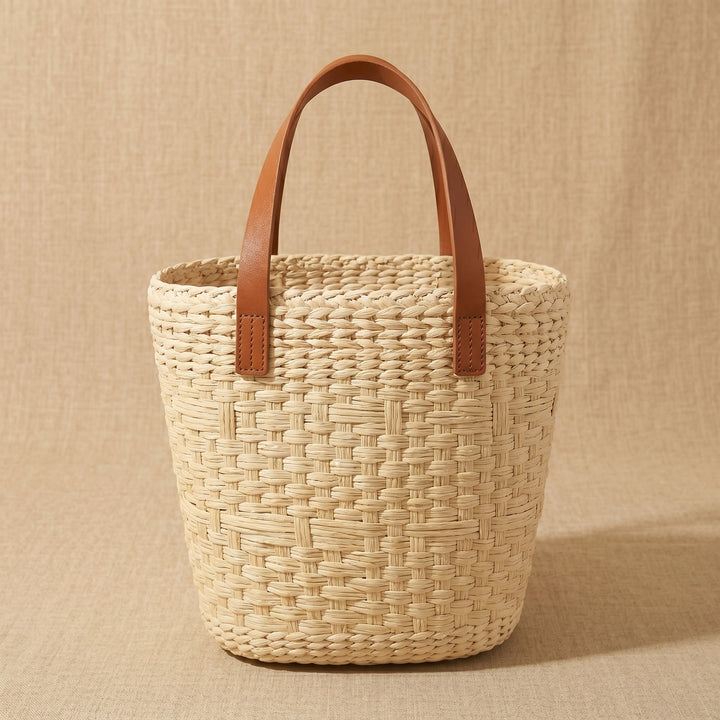 Woven basket with brown leather handles back