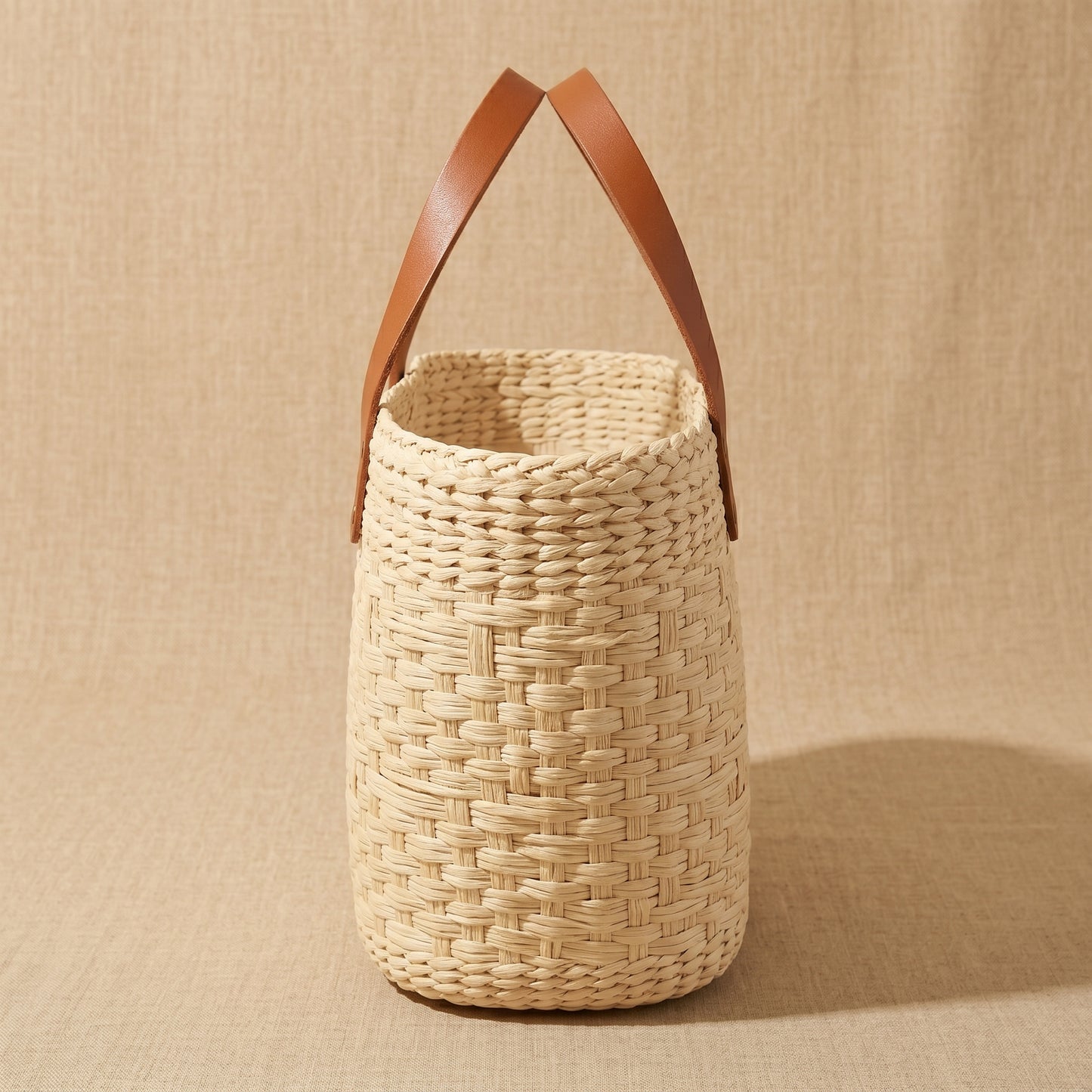 Woven basket with leather handles side